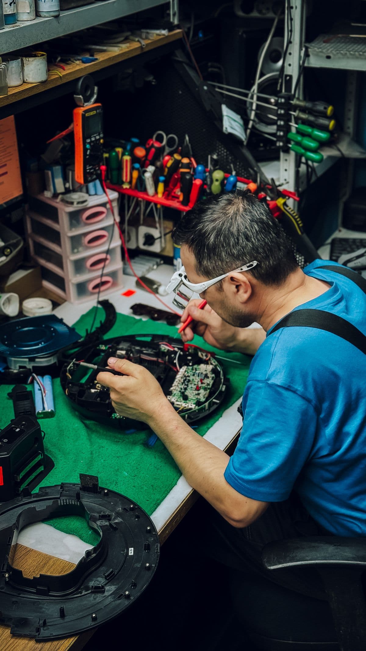 Technician repairing an electronic device on a workbench